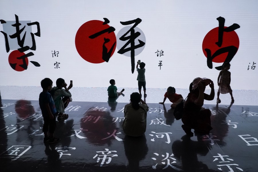 Calligraphy. Visitors take photos as Chinese characters are shown on electronic screens in an exhibition on Chinese characters in Chinese National Museum in Beijing, capital of China, Aug. 24, 2019. Photo: Xinhua/Shen Bohan