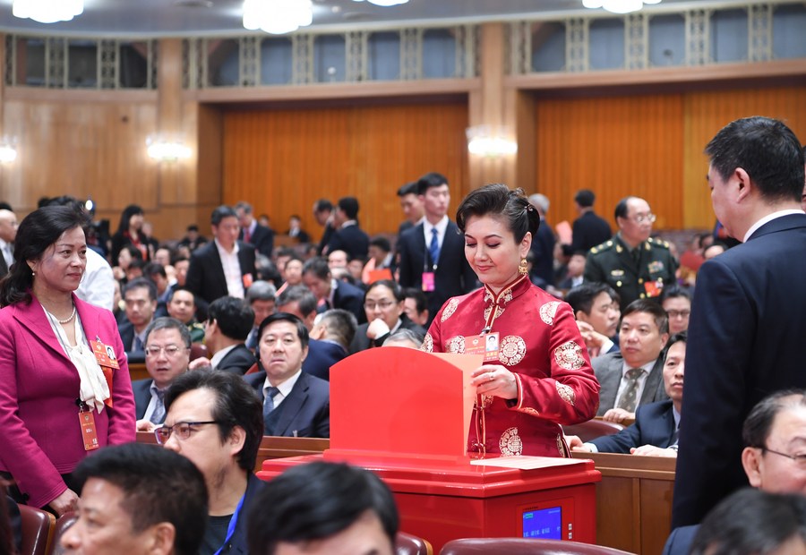 A member of the 13th National Committee of the Chinese People's Political Consultative Conference (CPPCC) casts her ballot at the fourth plenary meeting of the first session of the 13th National Committee of the CPPCC at the Great Hall of the People in Beijing, capital of China. Photo: Xinhua/Zhang Ling