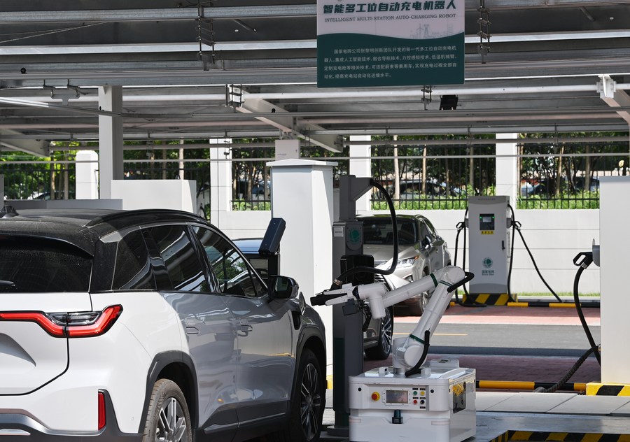 A robot operates a charging device at the Jinmenhu New Energy Vehicle Integrated Service Center in north China's Tianjin, Aug. 18, 2021. Xinhua/Li Ran/Xinhua.